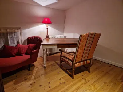 a room with a desk with a lamp and a chair at Charmante petite grange - 5 Couchages in Nalzen