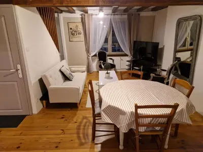 a living room with a couch and a table and chairs at Charmante petite grange - 5 Couchages in Nalzen