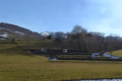 a grassy field with two white structures in a field at Charmante petite grange - 5 Couchages in Nalzen