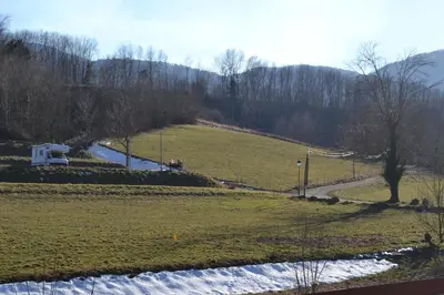 a view of a field with a road and a river at Charmante petite grange - 5 Couchages in Nalzen