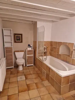 a bathroom with a tub and a toilet and a sink at Charmante petite grange - 5 Couchages in Nalzen