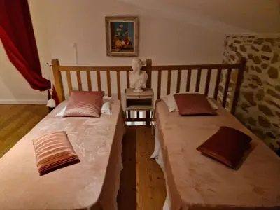 two twin beds in a room with a table at Charmante petite grange - 5 Couchages in Nalzen