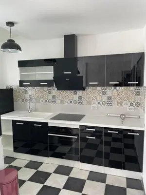 a kitchen with black and white appliances and a checkered floor at Gîte-appart privé du Domaine Spa piscine sauna in Lescout