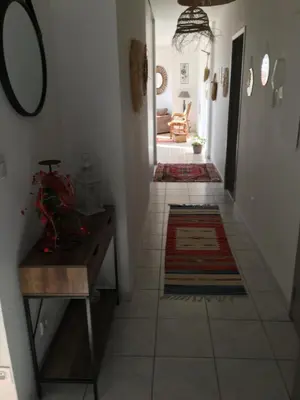 a hallway with a table and a rug on a floor at Appart République in Narbonne