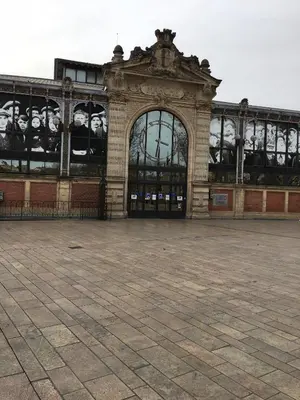 a large building with an archway in a courtyard at Appart République in Narbonne