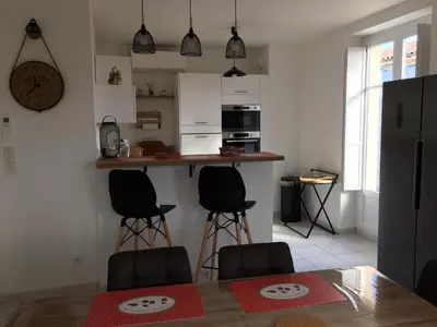 a kitchen with a table and chairs and a counter at Appart République in Narbonne