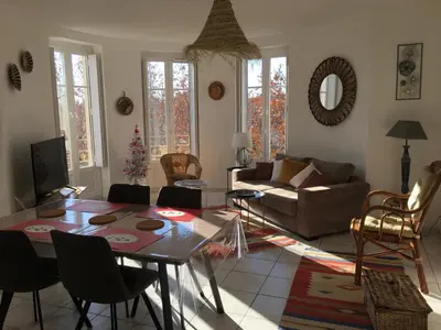 a living room with a table and a couch at Appart République in Narbonne