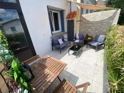 an outdoor patio with two chairs and a table and chairs at L'esplanade, appartement en centre-ville au calme in Puisserguier