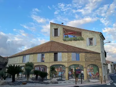 a building with a clock on the top of it at L'esplanade, appartement en centre-ville au calme in Puisserguier