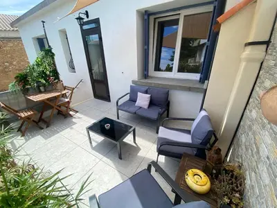 an outdoor patio with chairs and a table at L'esplanade, appartement en centre-ville au calme in Puisserguier