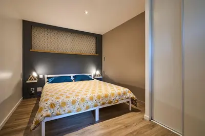 a bedroom with a large bed with blue pillows at Domaine du Fresquel in Pezens