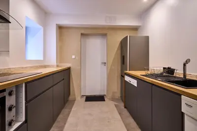a kitchen with gray cabinets and a refrigerator at Domaine du Fresquel in Pezens