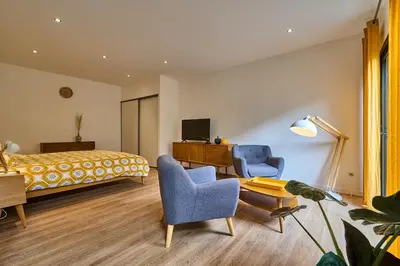 a bedroom with a bed and two chairs and a table at Domaine du Fresquel in Pezens