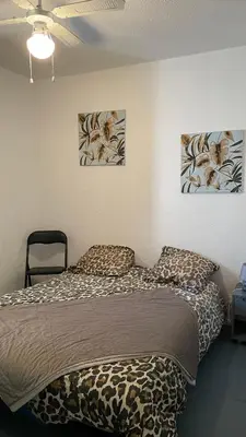 a small room with a bed and a microwave at APPARTEMENT T2 GRUISSAN PLAGE DANS RÉSIDENCE CALME in Gruissan