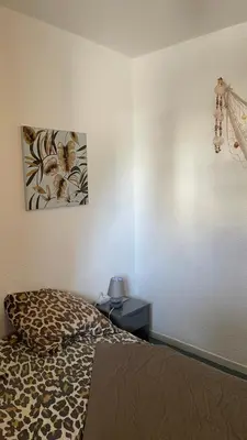 a dining room table with chairs and a kitchen with a window at APPARTEMENT T2 GRUISSAN PLAGE DANS RÉSIDENCE CALME in Gruissan
