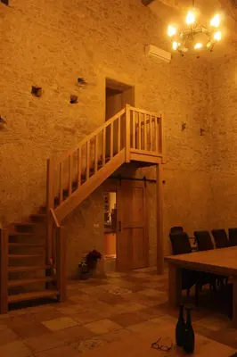 a staircase in a room with a table and chairs at Domaine de la Couderquié in Lautrec