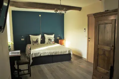 a bedroom with a bed with a blue wall at Domaine de la Couderquié in Lautrec