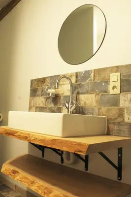 a bathroom sink on a wooden counter with a mirror at Domaine de la Couderquié in Lautrec