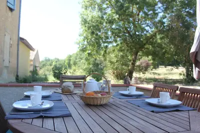 a wooden table with a basket of fruit on it at Domaine de la Couderquié in Lautrec
