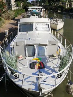 a white boat docked at a dock in the water at Bateau Fellowship in Narbonne