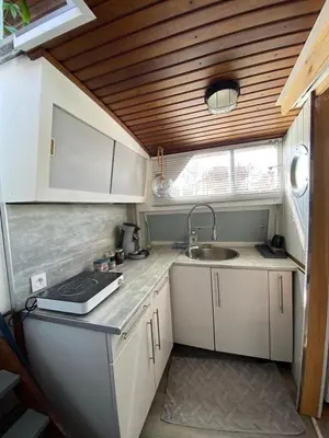 a small kitchen with white cabinets and a sink at Bateau Fellowship in Narbonne