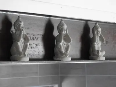 a row of white statues on a shelf at Love room 