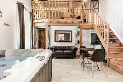 a loft bathroom with a tub and a staircase at Love room 