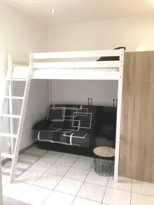 a bedroom with a bunk bed with a white bunk ladder at keep calm in Pamiers studio indépendant in Pamiers