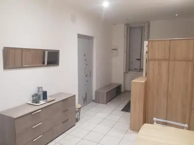 a room with a kitchen with wooden cabinets at keep calm in Pamiers studio indépendant in Pamiers