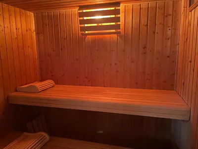 a wooden sauna with a wooden bench in it at Chambre au Domaine Spa-piscine sauna in Lescout