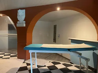 a blue table in a room with an archway at Chambre au Domaine Spa-piscine sauna in Lescout