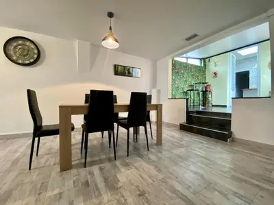 a dining room with a table and black chairs at L'Appartement Jebari - Esprit loft Carcassonne proche cité médiéval et aéroport in Carcassonne