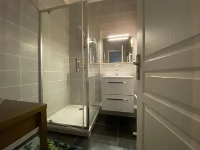 a bathroom with a shower with a glass door at L'Appartement Jebari - Esprit loft Carcassonne proche cité médiéval et aéroport in Carcassonne