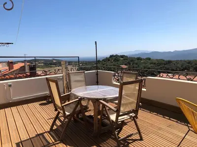 a table and chairs on a balcony with a view at Charmante maison de village avec toit terrasse in Montalba-le-Château