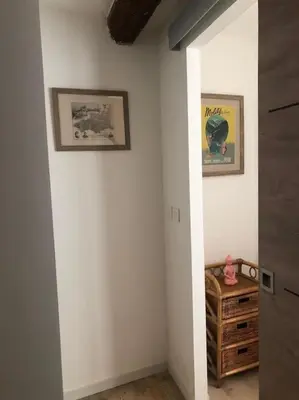 a hallway with two pictures on the wall and a table at Charmante maison de village avec toit terrasse in Montalba-le-Château