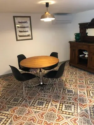 a wooden table and chairs in a room at Charmante maison de village avec toit terrasse in Montalba-le-Château