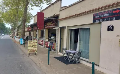a building with a table outside of it on a street at T2 tout confort, parking gratuit, vue lac et nature in Revel