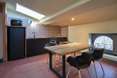 a kitchen with a wooden table and chairs at AUTOUR DU CHATEAU in Carcassonne