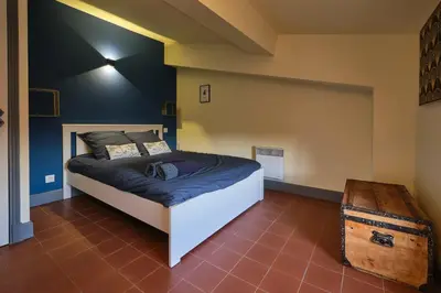 a bedroom with a bed and a wooden trunk at AUTOUR DU CHATEAU in Carcassonne