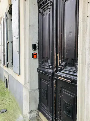a black door with a red box on the side of a building at AUTOUR DU CHATEAU in Carcassonne