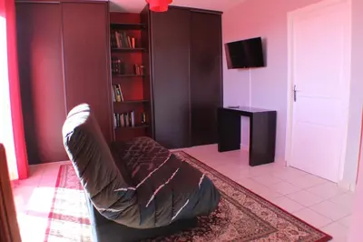 a living room with a couch and a book shelf at Chez Carole et Michel en Minervois in Rieux-Minervois
