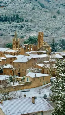 a town with snow covered roofs and a church at MAISON ALETEIA*** DECOUVERTE ET SERENITE in Alet-les-Bains