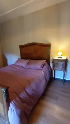 a bedroom with a bed and a night stand with a lamp at MAISON ALETEIA*** DECOUVERTE ET SERENITE in Alet-les-Bains