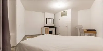 a white bedroom with a bed and a fireplace at DUPLEX DU GET in Revel
