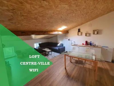 a living room with a couch and a table at LOFT DU GET in Revel