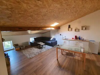 a living room with a couch and a table at LOFT DU GET in Revel