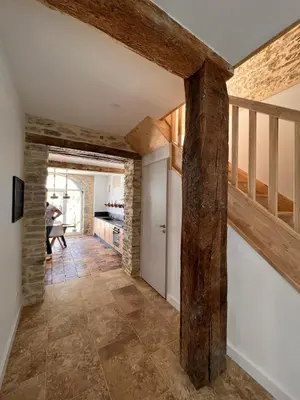 a hallway with wooden beams in a kitchen with a staircase at LE MOULIN DU VIVIER in Saint-Martin-Lalande
