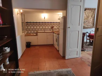 a kitchen with a white refrigerator and a tile floor at GITE Le Logis Barbès in Carcassonne