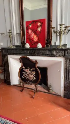 a chair sitting in front of a fireplace at GITE Le Logis Barbès in Carcassonne