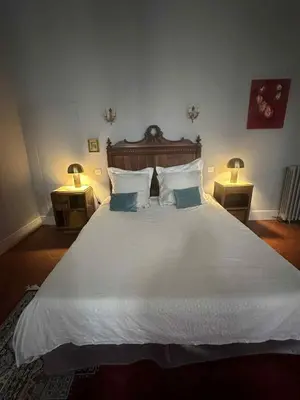 a bedroom with a large white bed with two lamps at GITE Le Logis Barbès in Carcassonne